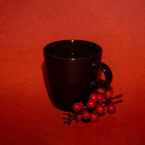 Cup of coffee with flowers creative concept on a red background.